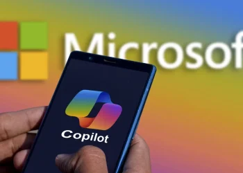 ایجاد یک برنامه بدون کدنویسی در Microsoft Copilot امکان پذیر شد 2 دست فردی گوشی هوشمندی را به صورت افقی نگه داشته که نمایشگر آن لوگوی رنگینکمانی Copilot را نشان میدهد؛ پسزمینه، لوگوی Microsoft را با افکت گرادیان رنگی منعکس میکند.