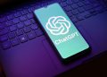 شایعه: ChatGPT Pro Max با اشتراک ماهانه 500 دلار ارائه می شود 18 Phone showing the ChatGPT logo on a teal screen resting on a laptop keyboard.