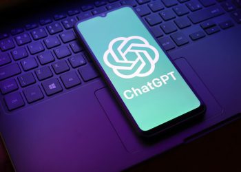 شایعه: ChatGPT Pro Max با اشتراک ماهانه 500 دلار ارائه می شود 14 Phone showing the ChatGPT logo on a teal screen resting on a laptop keyboard.