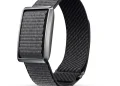 عکس محصول دستبند هوشمند Pebble Qore Ultra روی پس‌زمینه سفید. بند بافته‌شده خاکستری تیره از داخل قاب فلزی مستطیلی عبور کرده، لایه داخلی بند مشکی و براق است و انتهای بند با یک سنجاق کوچک مشکی بسته می‌شود.