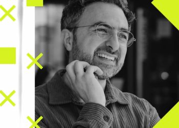 The CEO of Microsoft AI warns about the dangers of artificial intelligence and the need to slow down development 13 پرتره سیاه و سفید مصطفی سلیمان خندان با موهای کمی جوگندمی، عینک گرد نازک و ریش کوتاه که در حالت فکری دستش را زیر چانهاش گذاشته، در قالب طراحی گرافیکی با اشکال هندسی لیمویی مانند ضربدر و مربع