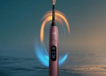 مسواک برقی هوشمند Philips Sonicare به رنگ برنزی متالیک همراه با خطوط نورانی آبی و طلایی چرخان در اطراف سری مسواک