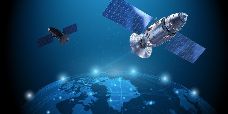 گوگل در حال آماده شدن برای راه اندازی یک مرکز داده آزمایشی به فضا است 1 Two satellites with large solar arrays orbit a glowing blue Earth, illustrating space technology and communication links.