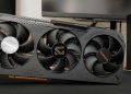 Triple‑fan graphics card from Gigabyte installed in a PC, visible heatsink and case side panel in the background, slogan 'Dominating the Games' on the card.