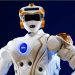 ناسا می خواهد ربات های انسان نما را به ماه بفرستد 8 NASA humanoid robot in white armor with orange joints and a visible NASA logo on the chest, posed against a dark blue background.