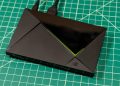 تکه های رونق هوش مصنوعی به سخت افزار محبوب انویدیا رسید 17 تیوی باکس Nvidia Shield TV Pro با بدنه مشکی، طراحی زاویهدار و خط نورانی سبز روی صفحه کار مدرج سبز