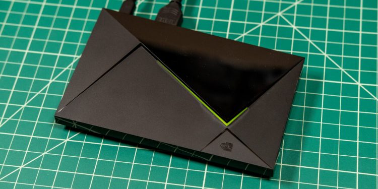 تی‌وی باکس Nvidia Shield TV Pro با بدنه مشکی، طراحی زاویه‌دار و خط نورانی سبز روی صفحه کار مدرج سبز