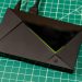تی‌وی باکس Nvidia Shield TV Pro با بدنه مشکی، طراحی زاویه‌دار و خط نورانی سبز روی صفحه کار مدرج سبز
