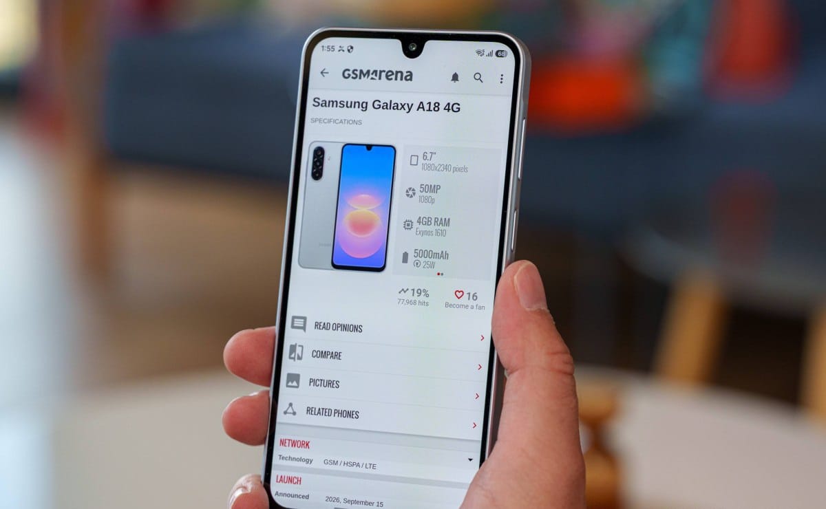 gsmarena_014 Hand holds a smartphone displaying the GSM Arena page for Samsung Galaxy A18 4G with specs and images on the screen
