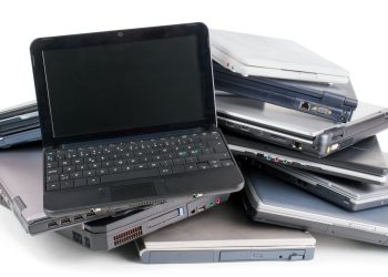 6 روش بسیار ساده برای استفاده مجدد از لپ تاپ خراب قدیمی 13 Pile of assorted laptops stacked in a heap, showing keyboards and side ports.
