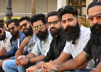 استفاده واقعی از ریش چیست؟ 16 Seven men with beards and sunglasses sit in a row outdoors, posing for a group photo.