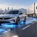 هوندا می خواهد خودروهای برقی را در جاده شارژ کند 8 Silver Honda sedan leading a large white truck on a highway, with blue holographic lines suggesting connected autonomous driving.