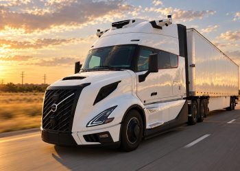 White semi-truck with trailer driving on a highway at sunset, emphasizing motion and warm sky colors.