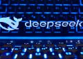 ایالات متحده استفاده از DeepSeek را در سازمان های دولتی ممنوع کرد 15 لوگو و نوشتهی دیپسیک روی صفحهنمایش لپتاپ در کنار کیبورد با نور پسزمینهی آبیرنگ.