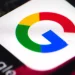 نمای نزدیک و باکیفیت از اپلیکیشن یا نماد گوگل (Google) با رنگ‌های چهارگانه مشخص روی صفحه نمایشگر و متن «Google» در کنار آن.