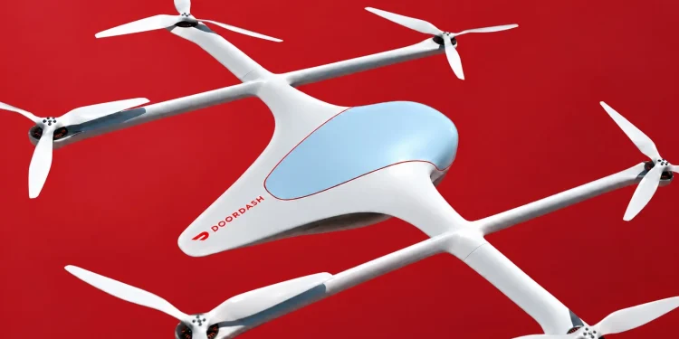 DoorDash می گوید پهپاد جدیدش غذا را در کمتر از 5 دقیقه تحویل می دهد 1 Quadcopter delivery drone in white with four propellers, blue cockpit window, and a Doordash logo on the fuselage against a red background.