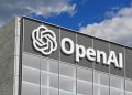 Exterior of a modern office building with a large OpenAI sign and logo on the facade.