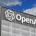 Exterior of a modern office building with a large OpenAI sign and logo on the facade.