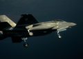حسگر لیزری چینی موفق شد جنگنده F-35 آمریکایی را شناسایی کند 17 F-35 stealth fighter jet in mid-flight over the ocean with landing gear down, side view of a gray military aircraft.
