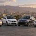 قیمت خودرو در بازار تهران; ساینا 1.8 میلیارد و ریرا 4.77 میلیارد تومان اعلام شد 8 Four sedans lined up on a parking area with a city skyline and snow-capped mountains in the distance at sunset.