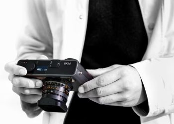 ورشکستگی Pixii باعث شد سری دوربین Leica M بدون رقیب باقی بماند 5 شخصی در حال نگهداشتن دوربین عکاسی مدرن Pixii با لنز متصل و نمای سیاهوسفید.