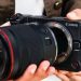 کانن نسبت به افزایش قیمت دوربین عکاسی هشدار داد 8 فردی دوربین بدونآینه Canon EOS RV را در دست گرفته و لنزی بزرگ را به بدنه آن متصل میکند